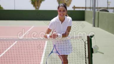 微笑的年轻女子在网球场上捧场